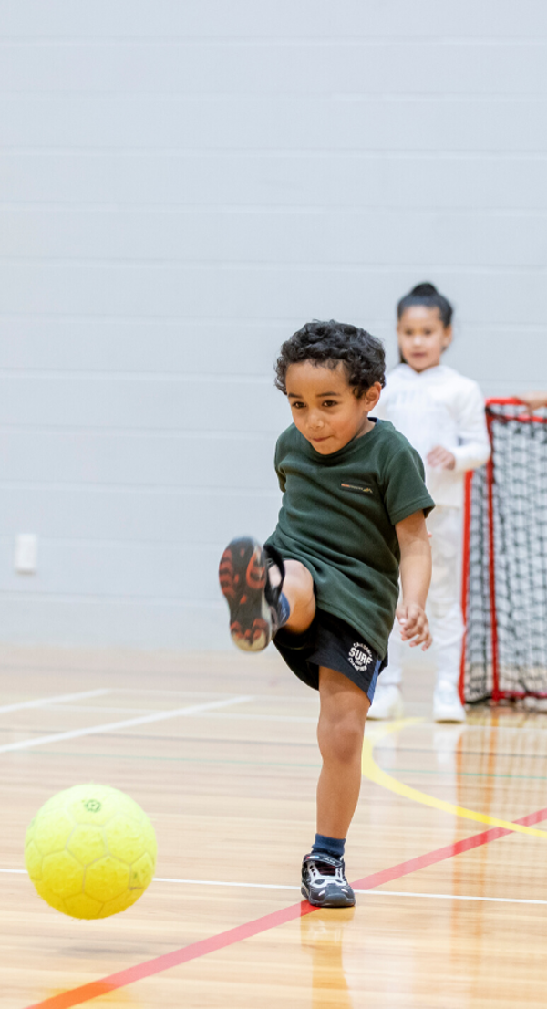 Side image boy kicking ball in stadium