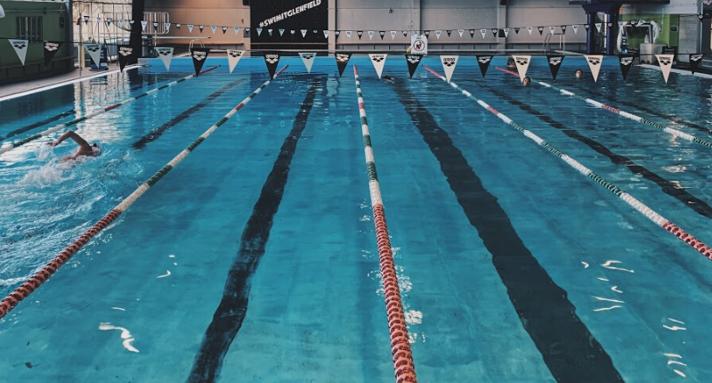a photo of the glenfield pool with lane ropes and a lone swimmer 