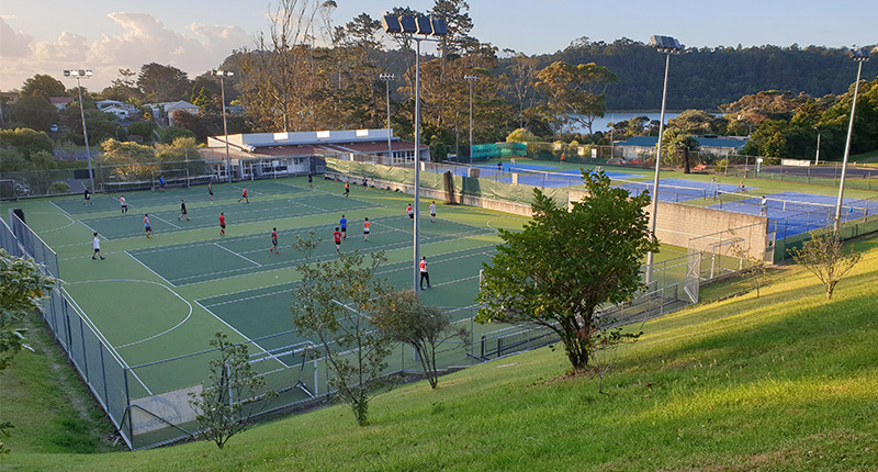 Members on an outdoor court overlooking Beach Haven Sports Club 