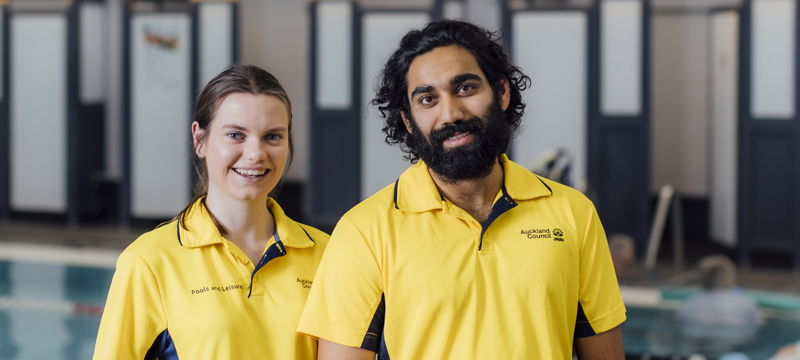 female and male lifeguards standing by a pool