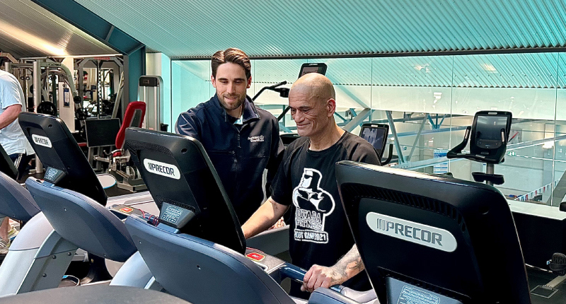 gym instructor showing member how to use the treadmill